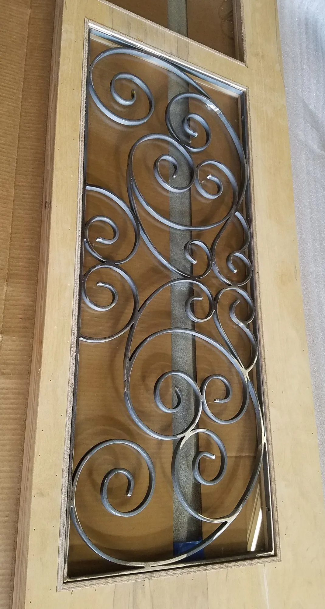 Forged scroll insert for a wood door