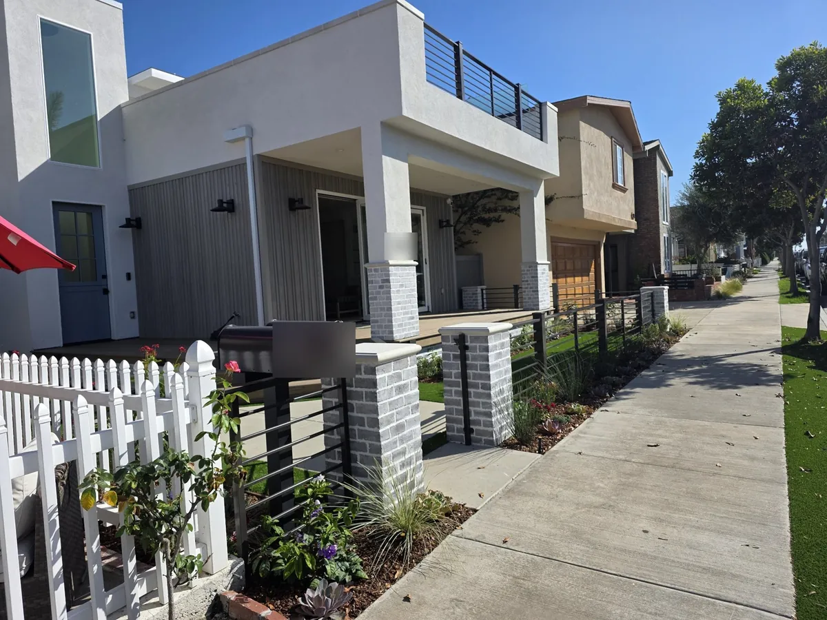 Modern fence between brick pillars